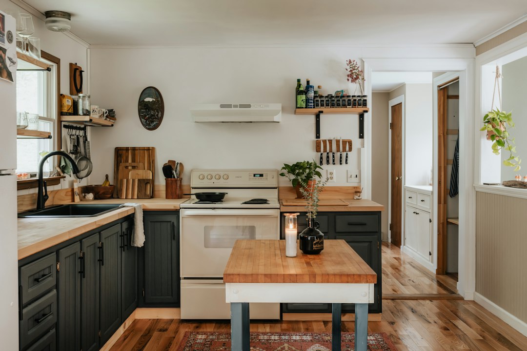 Dapur kecil dengan penataan rapi, kabinet modern, dan cahaya alami